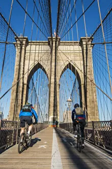 Cyclists riding their bikes on Brooklyn Bridge, New York, USA