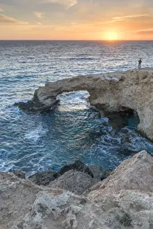 Ayia Napa Prints: Cyprus, Ayia Napa, Cape Greco, man at sunset standing over the Love Bridge