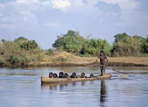 A Dassanech man ferries people in a large dug-out canoe A Dassanech man ferries people in a large dug-out canoe