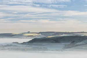 Dawn mist around Hambledon Hill from Bullbarrow Hill, Dorset, England, UK