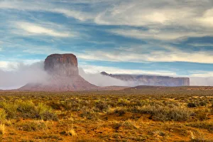 Desert landscape with butte surrounded by low fog, Monument Valley Navajo Tribal Park Desert landscape with butte surrounded by low fog, Monument Valley Navajo Tribal Park