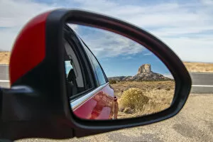 Desert landscape with lonely butte hill reflected into a car side mirror, Navajo Nation