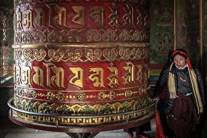 Images Dated 14th September 2023: Devotee spinning prayer wheel in temple at Boudhanath Stupa, Kathmandu, Nepal