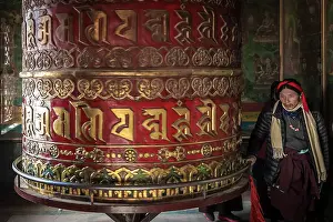 Prayer Prints: Devotee spinning prayer wheel in temple at Boudhanath Stupa, Kathmandu, Nepal
