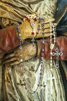 Prayer Gallery: Devotional rosaries in the hands of the wooden statue of Mary. Abruzzo, Italy