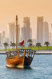 Dhow traditional sailing vessel with the financial area skyline behind, Doha, Qatar