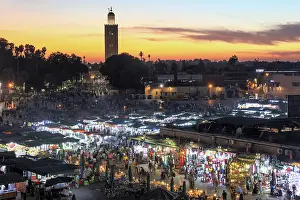 Background Prints: Djemaa el Fna and crowds at dusk, Koutoubia Minaret in the background, Marrakech, Morocco