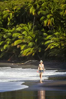 Caribbean Islands Collection: Dominica, Hampstead. A woman walks along No 1 Beach. (MR)