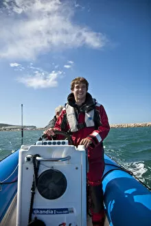 Dorset, England. Sailing coach Ian Martin prepares a course for the GBR 29ers sailing
