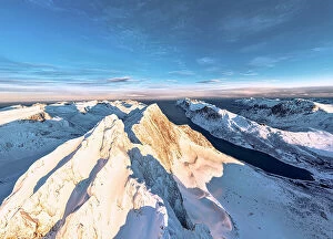 Images Dated 19th September 2023: Dramatic sky at dawn over majestic Breidtinden mountain peak covered with snow, aerial view