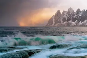 Mountain Peak Prints: Dramatic sky at sunset over sharp pinnacles of mountains facing the rough arctic sea