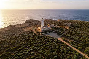 Horizon Over Water Prints: Drone view of the lighthouse Capo Murro di Porco standing on top of a cliff surrounded by Ionian sea at sunrise