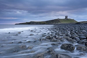 Images Dated 25th February 2015: Dunstanburgh Castle above the boulder covered Embleton Bay, Northumberland, England