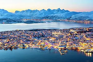 Building Exterior Prints: Dusk over snowy mountains surrounding the illuminated Tromso city and harbor seen from Fjellheisen cable car viewpoint