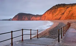 Early morning sunlight glows against the distinctive red cliffs of High Peak, viewed