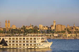 Egypt, Luxor, Nile cruise boat passing intont of Luxor temple