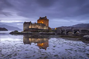 Reflected Prints: Eilean Donan Castle illuminated at twilight, Dornie, Scotland, UK