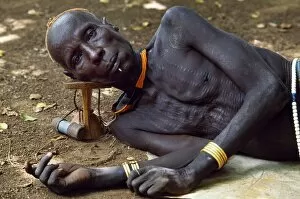 Body Adornment Collection: An elder of the Karo tribe rests with his head on his