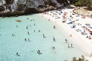 Elevated view of Cala Macarelleta beach crowded in summer, Menorca, Balearic Islands