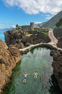 Rock Formations Collection: Elevated view of couple swimming in natural volcanic rock pools near Aquarium of Madeira