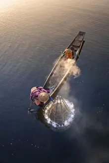 Two People Prints: Elevated view of fisherman catching fish from boat using traditional conical net