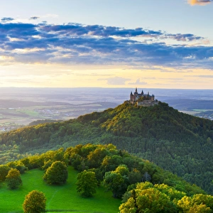 Elevated view towards Hohenzollern Castle and sourrounding countryside illuminated at sunset Elevated view towards Hohenzollern Castle and sourrounding countryside illuminated at sunset