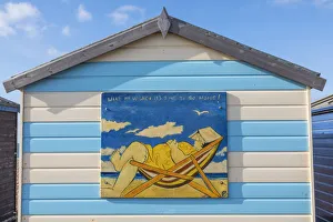 England, Hampshire, Hayling Island, Funny Painting of Fat Lady Asleep in Deck Chair on side of Colourful Beach Hut