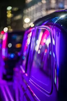 England, London, Soho, London taxis lit by neon lights