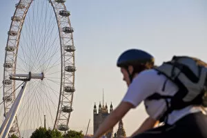 Cylces Gallery: England, London, Westminster, Man cycling with The London Eye & The Houses of Parliament