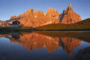 Enrosadira on Pale di San Martino Dolomites reflecting on the lake of Segantini hut
