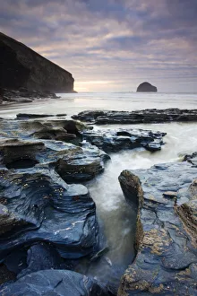Eroded slate rocks on the beach at Trebarwith Strand, looking towards Gull Rock