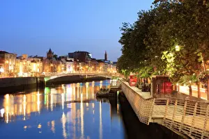 Europe, Dublin, Ireland, Halfpenny bridge by night reflecting on the Liffey river