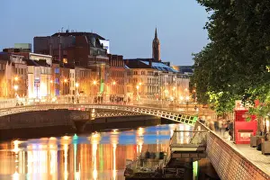 Europe, Dublin, Ireland, Halfpenny bridge by night reflecting on the Liffey river