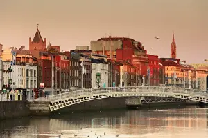 Europe, Dublin, Ireland, Halfpenny bridge at sunrise with buildings reflecting in
