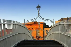 Europe, Dublin, Ireland, Halfpenny bridge at sunrise with buildings reflecting in