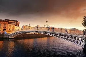 Images Dated 19th July 2017: Europe, Dublin, Ireland, people crossing Halfpenny bridge on the Liffey river at sunset