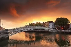 Tourists Gallery: Europe, Dublin, Ireland, people crossing Halfpenny bridge on the Liffey river at sunset