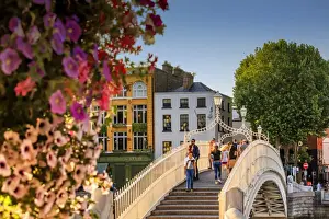 Europe, Dublin, Ireland, tourists crossing the famous Halfpenny bridge on the Liffey