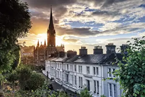 Europe, Ireland, Cork, Cobh Cathedral at colored houses at sunrise
