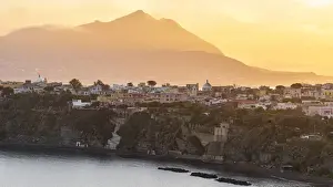 Borgo Prints: Europe, Italy, Campania. Procida island at sunset with the impressive Vesuvius in