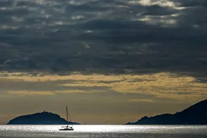 Europe, Italy, Island of Palmaria from La Spezia, a yacht travels though the Gulf Europe, Italy, Island of Palmaria from La Spezia, a yacht travels though the Gulf
