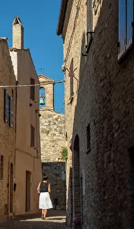 Hamlet Prints: europe, Italy, The Marches. A woman walking in a narrow street in the beautiful hamlet of Torre di Palme near Fermo