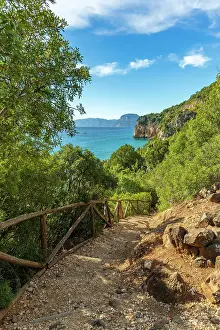 Trekking Prints: Europe, Italy, Sardinia. A path on coast near Cala Gonone to the beach in the morning light