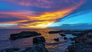Backlight Prints: Europe, Italy, Sardinia. Sunset with sea and rocks near to the beach Is Arutas