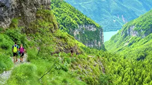 Hikers Prints: Europe, Italy, Trentino. A couple of hikers on the mountain path above the Lake of Molveno in the Brenta Dolomites