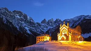 Europe, Italy, Veneto. The parish church of Falcade in the late evening with behind