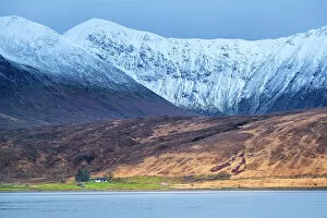 Images Dated 21st February 2023: Europe, UK, Scotland, Isle of Skye, crofters cottage set against dramatic snowy mountains