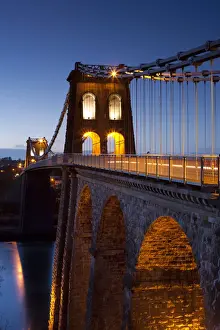 Suspension Bridge Prints: Evening illuminations on the Menai Bridge spanning the Menai Strait, North Wales, UK