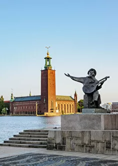 Evert Taube Statue with City Hall in the background at sunrise, Stockholm, Stockholm County, Sweden