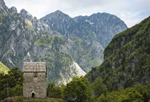 Albanian Prints: Exterior of building with The Accursed Mountains in background, Theth, Albania